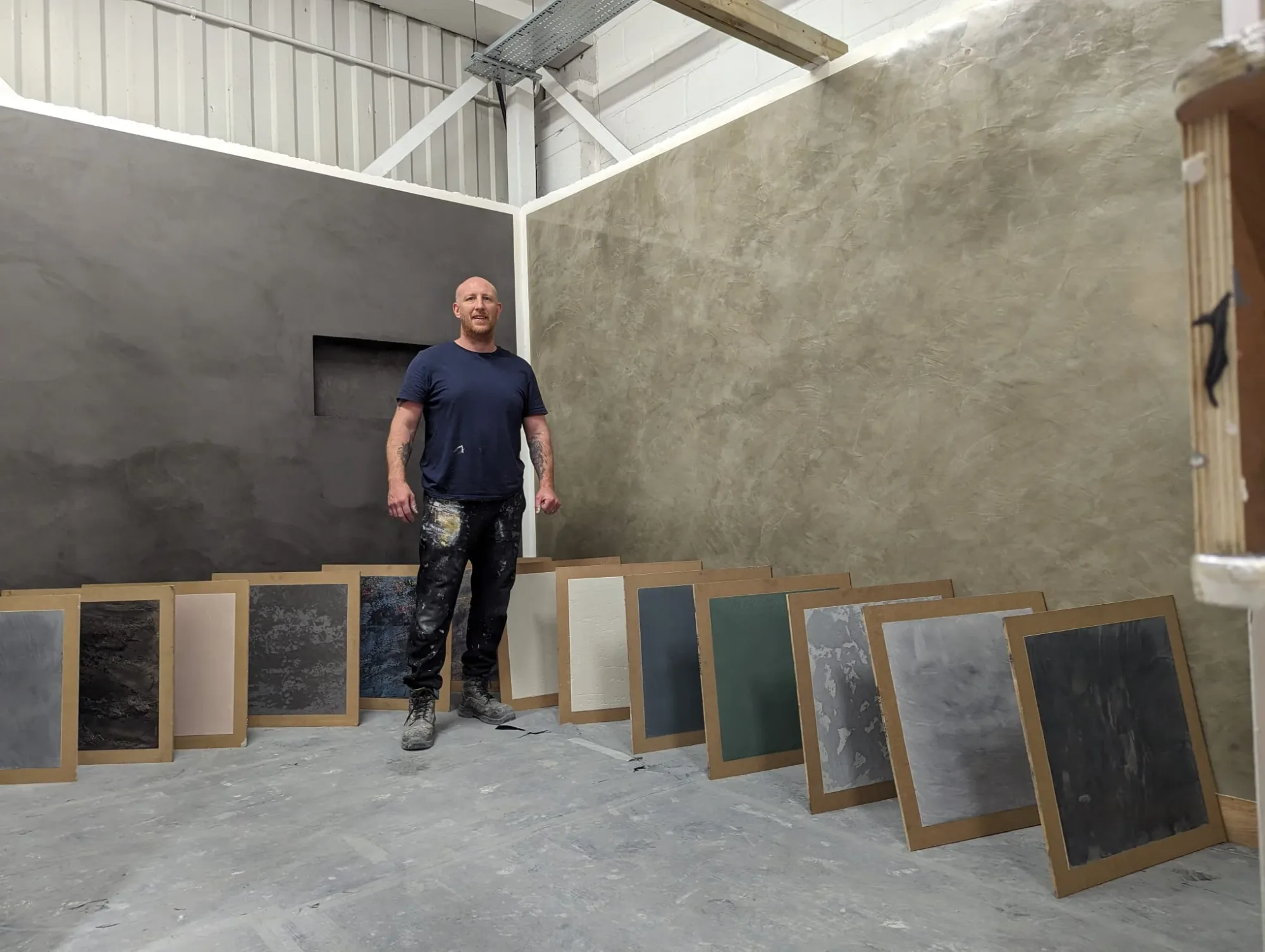 Polished Venetian plasterer with finished sample panels in the Dartford workshop